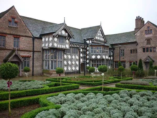 Black-and-white timber-framed rear of Ordsall Hall with its formal garden, Salford